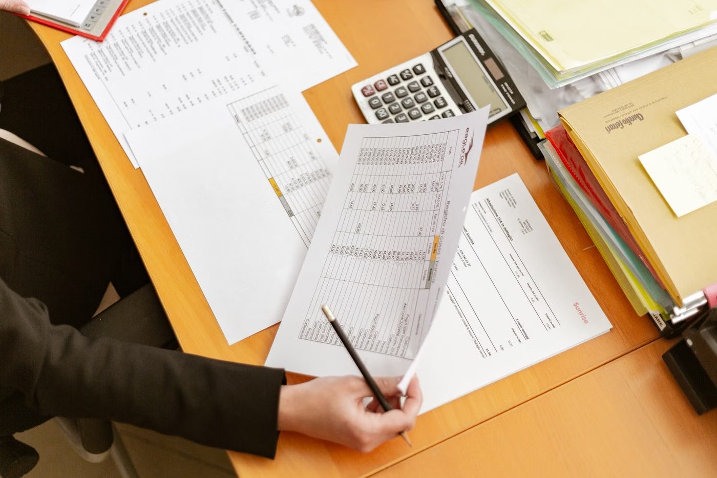 Transaction records under review with a pen